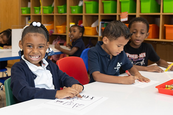 Elementary students working at a table together.
