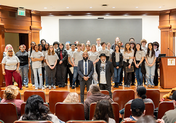 Two gentlemen standing in front of students on a stage.