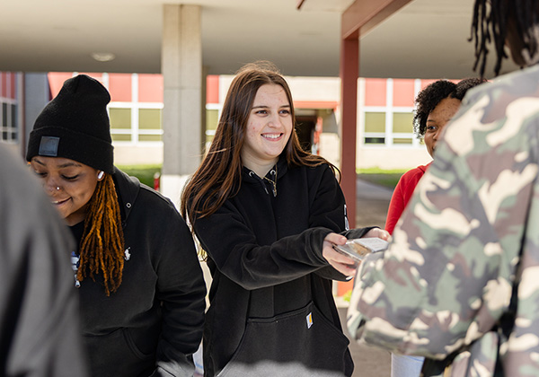 Students accepting meals from volunteers.